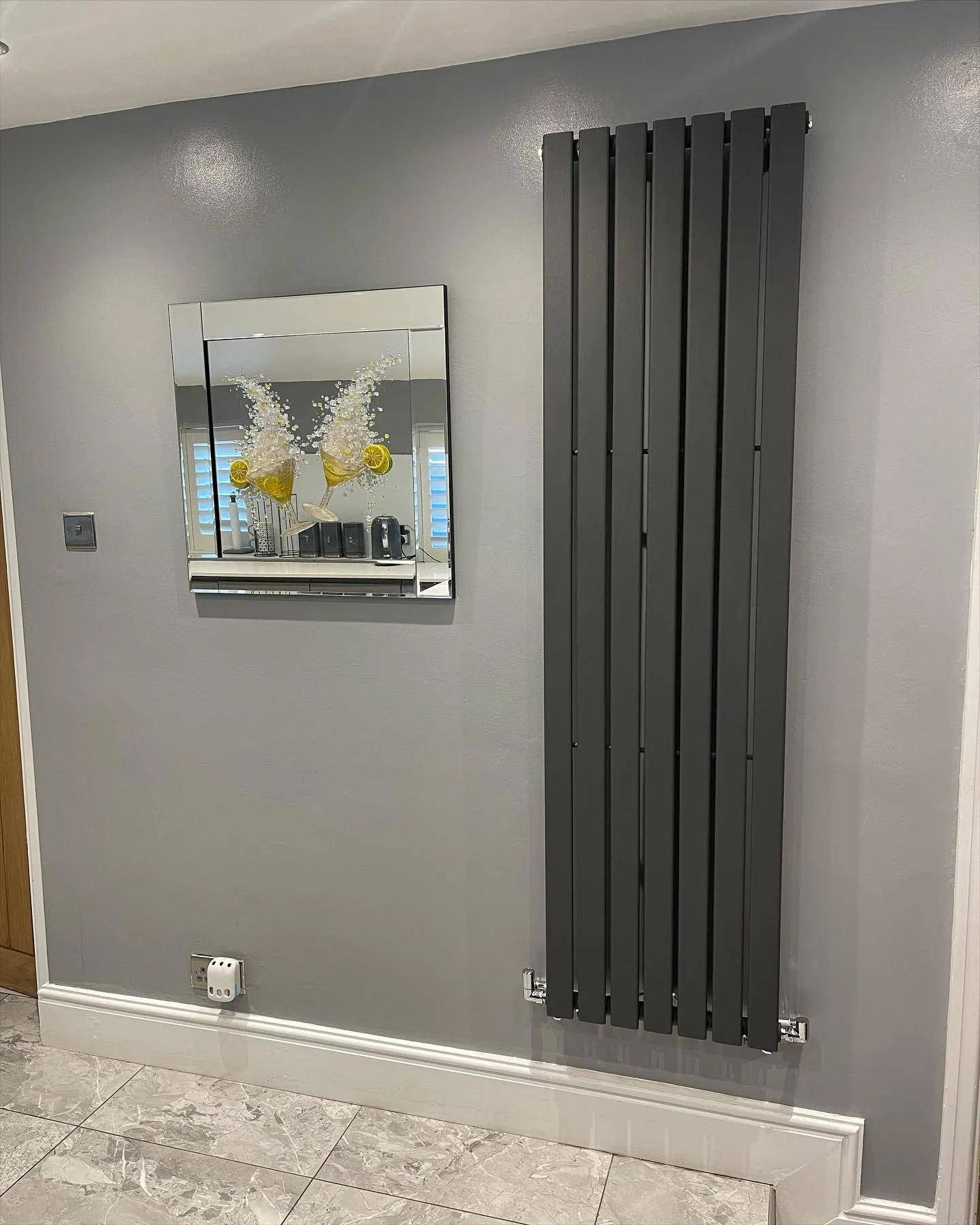 A bathroom with a radiator and a mirror on the wall.