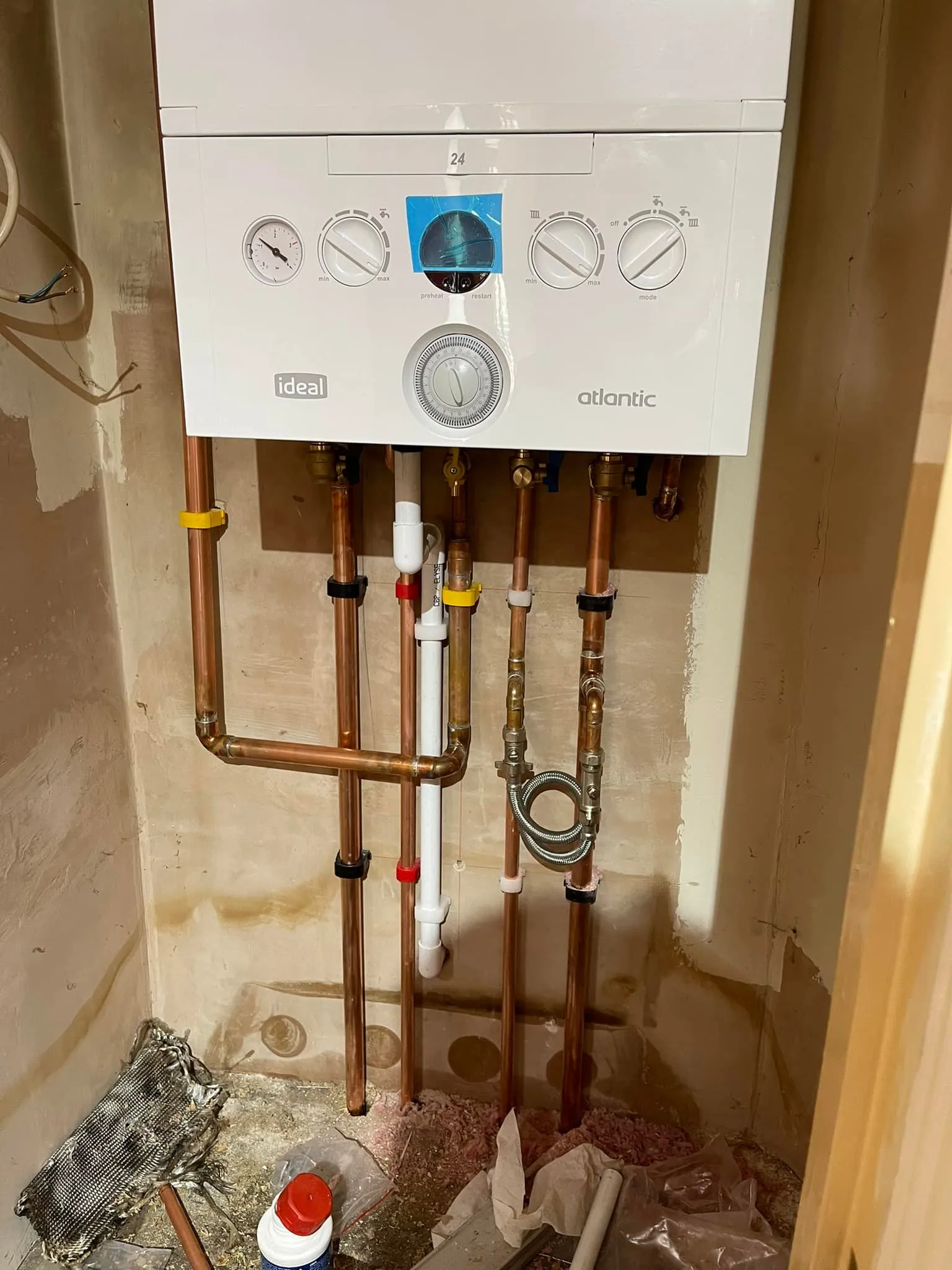 A tankless water heater in a bathroom under construction.