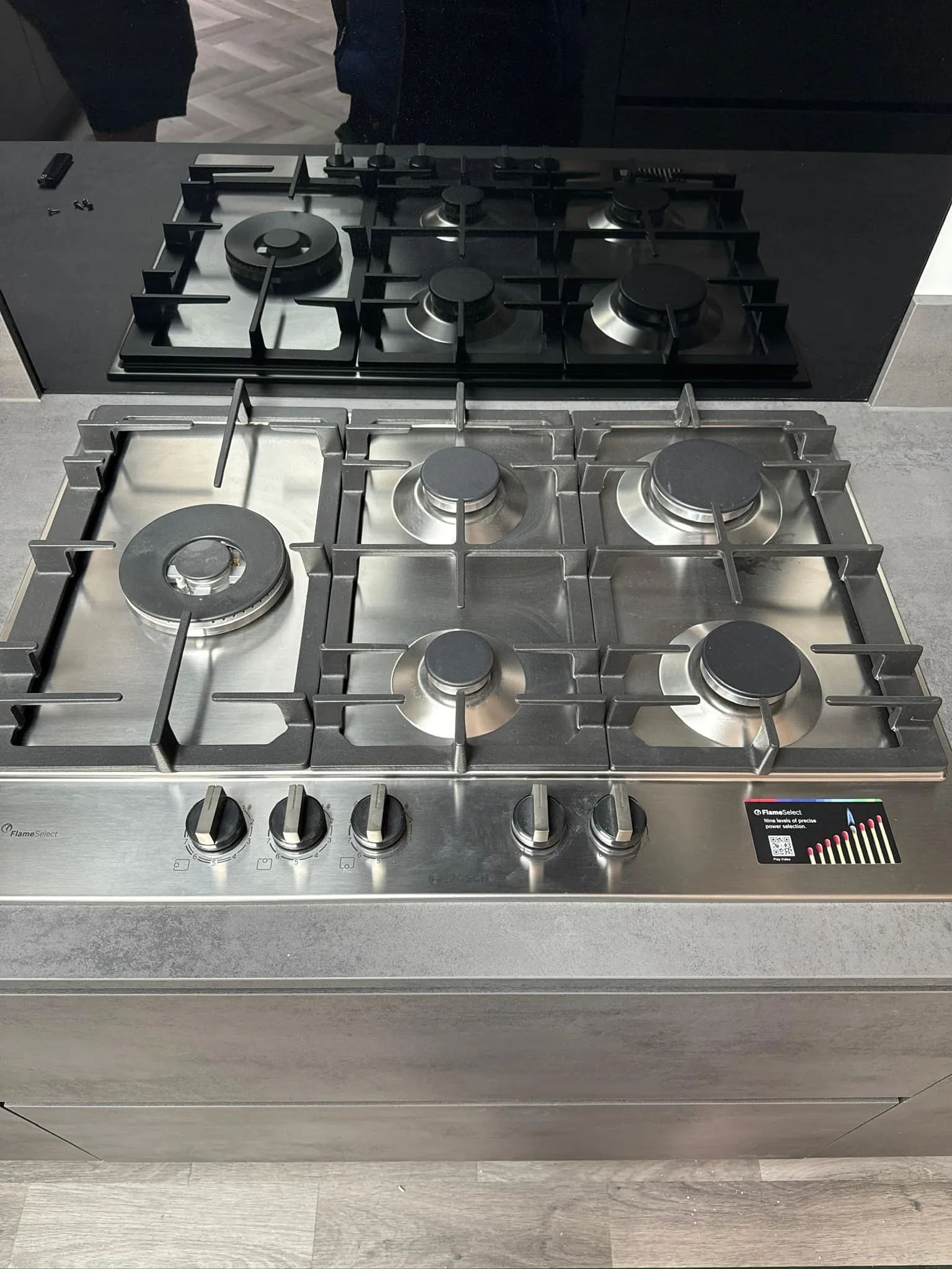 A stainless steel stove top with four burners.